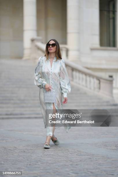 Maria Rosaria Rizzo wears brown marble print pattern sunglasses from Isabel Marant, silver earrings, a white and pale blue marble print pattern silk...