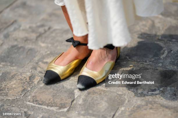 Alba Garavito Torre wears gold shiny leather and black toe-cap ballerinas from Chanel, during a street style fashion photo session, on June 06, 2023...