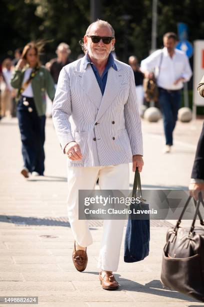 Alessandro Squarzi, wearing blue striped double breasted blazer, beige pants, and brown loafers, is seen at Fortezza Da Basso during Pitti Immagine...