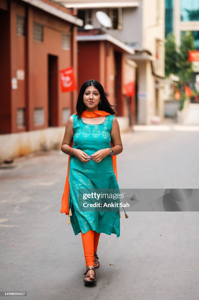 Young woman walking on road near old historical building