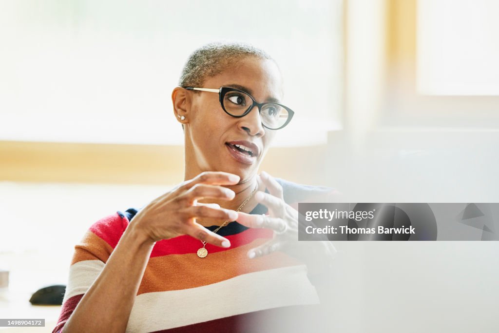 Medium shot businesswoman in discussion with colleague at workstation