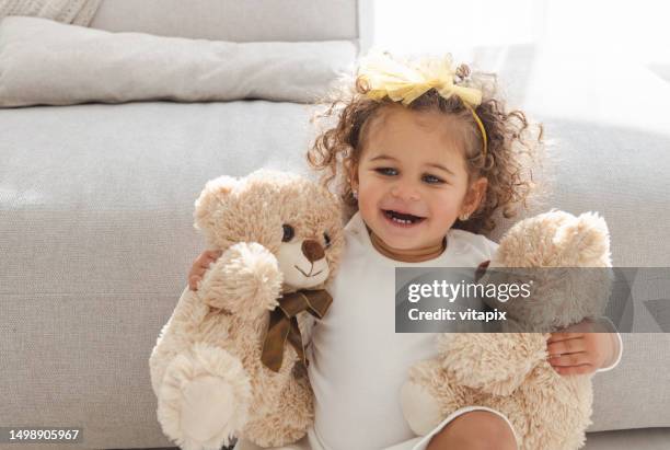 little girl playing with teddy bear - baby holding doll stock pictures, royalty-free photos & images