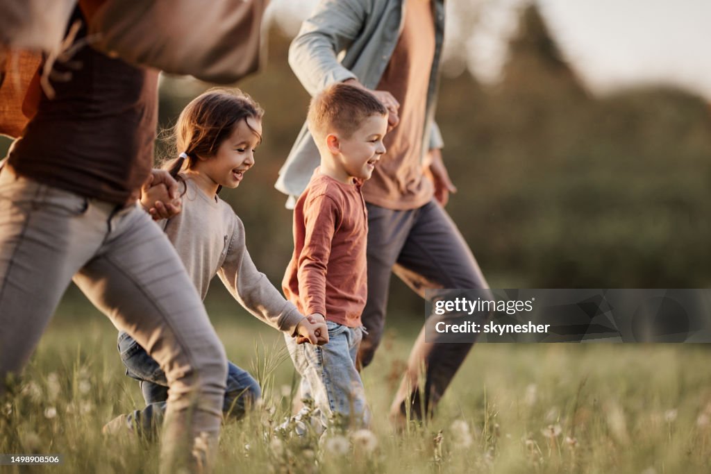 Unbeschwerte Kinder, die mit ihren Eltern im Park laufen.
