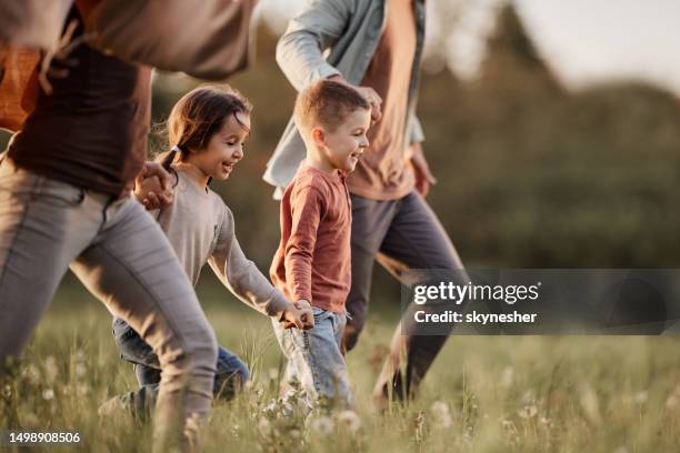 carefree kids running with their parents in the park. - family outdoors stockfoto's en -beelden