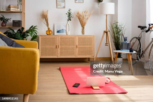 empty living room with a yoga mat on the floor. - colchoneta de ejercicio fotografías e imágenes de stock