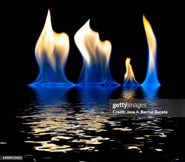 full frame of flames and natural fire reflected in the water on a black background. - incineration stock pictures, royalty-free photos & images