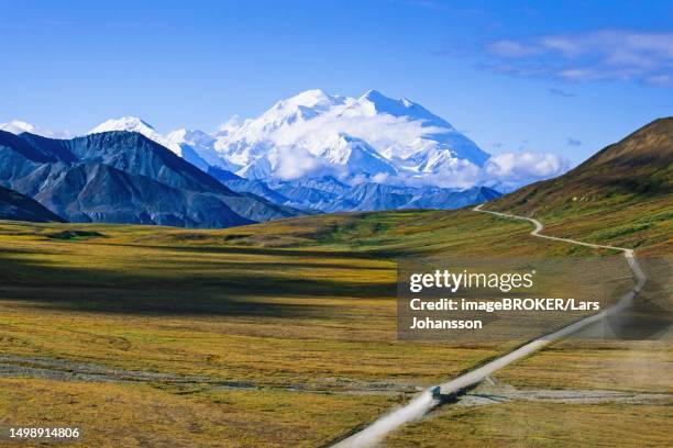road to mount denali in alaska with a bus and snow capped mountain peak in autumn, alaska, usa - mt mckinley ストックフォトと画像