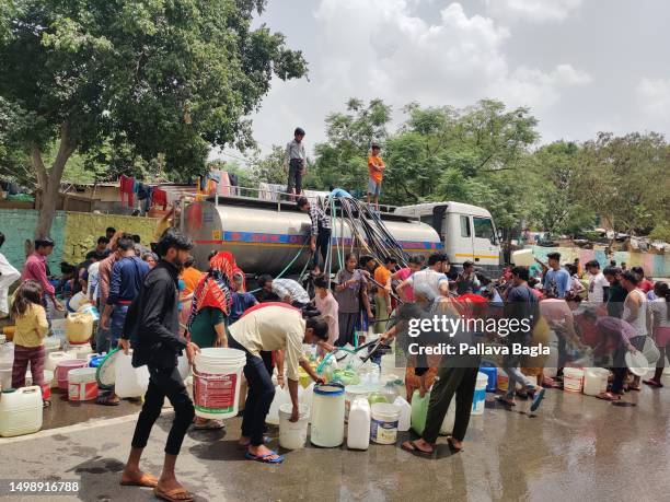 June 15: People scramble to collect drinking water in heart of New Delhi in the diplomatic enclave of Chanakya Puri where a tanker dispenses water to...