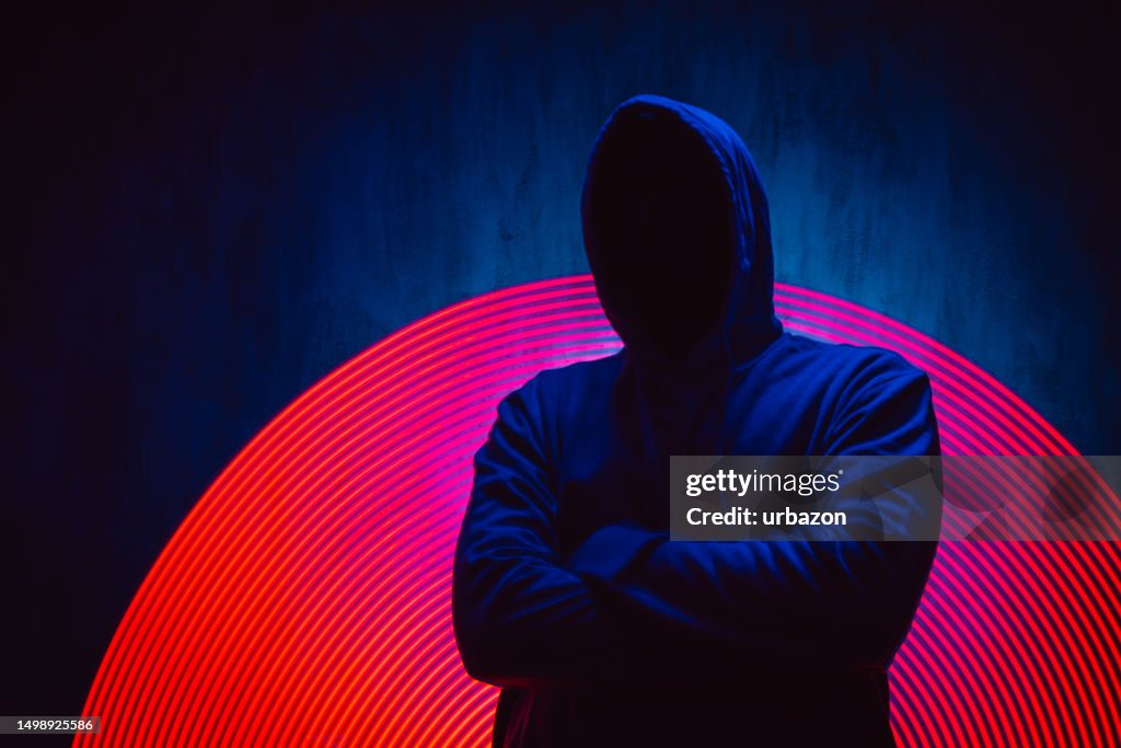 Scary Faceless Man In A Hoodie Under Neon Lights