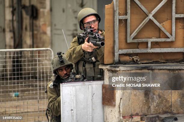 Israeli soldiers take aim during clashes in the centre of Hebron in the occupied West Bank on July 4, 2023. Israel's biggest military operation for...