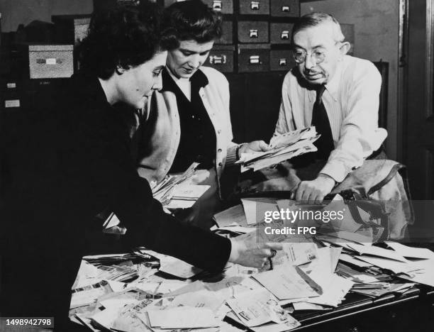 Voice of America employees Fricka Leistokow, Hilde Schonfeld and Morris Robinson sorting through the mail from overseas listeners to the Voice of...