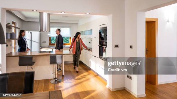 couple checking kitchen furniture at real estate showing - real estate showing stock pictures, royalty-free photos & images