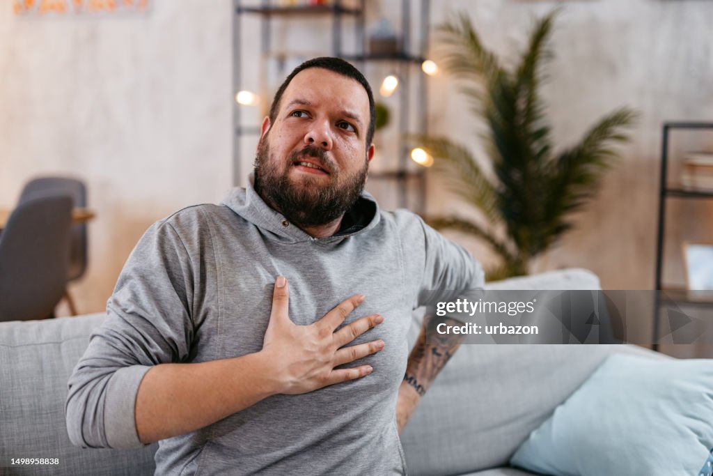 Man Suffering From Chest Pain Sitting Alone