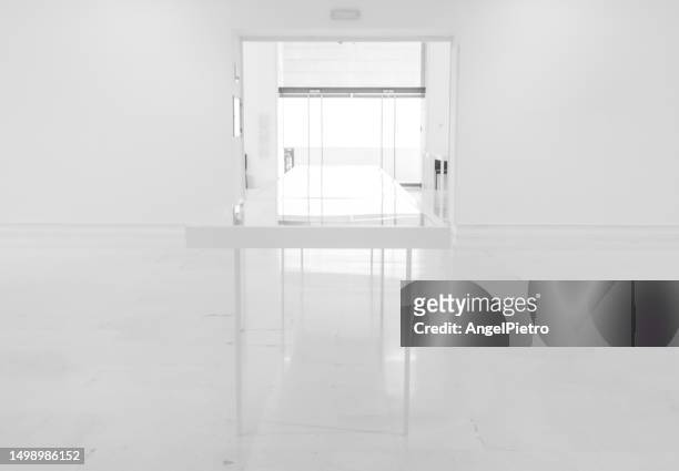 a composition with a large open room and a table in the foreground. - bright light open interior stock-fotos und bilder
