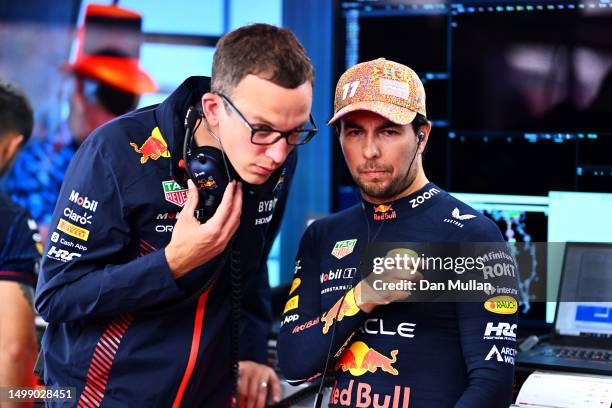 Sergio Perez of Mexico and Oracle Red Bull Racing talks with race engineer Hugh Bird in the garage during practice ahead of the F1 Grand Prix of...