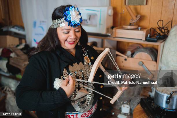 mapuche craftswoman carding and processing sheep wool with a niddy noddy in her vibrant textile workshop - indigenous american culture stock pictures, royalty-free photos & images