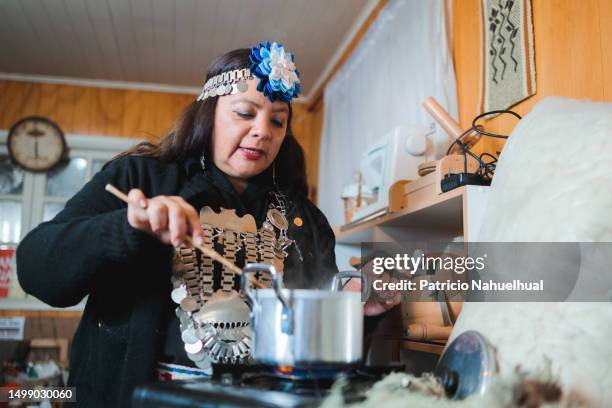 skillful mapuche craft worker woman dipping wool in a pot with natural vegetable dye, embracing the rich heritage of her textile workshop - indigenous american culture stock pictures, royalty-free photos & images