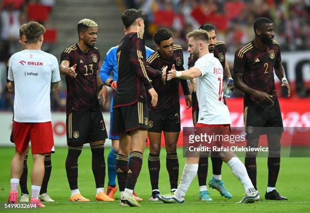 Jakub Blaszczykowski of Poland receives a guard of honour from team mates and players of Germany prior to the international friendly match between...