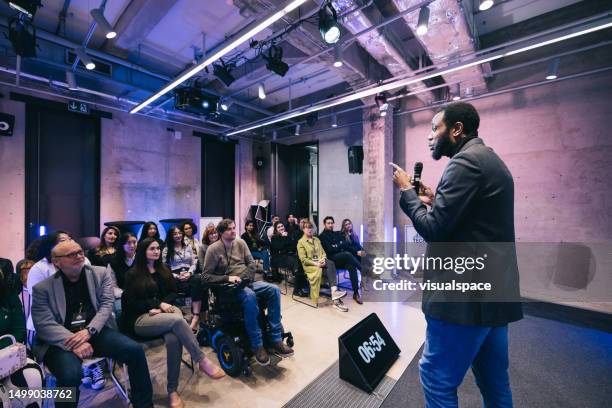 emprendedor dando una presentación para una audiencia diversa en la conferencia - orador público fotografías e imágenes de stock