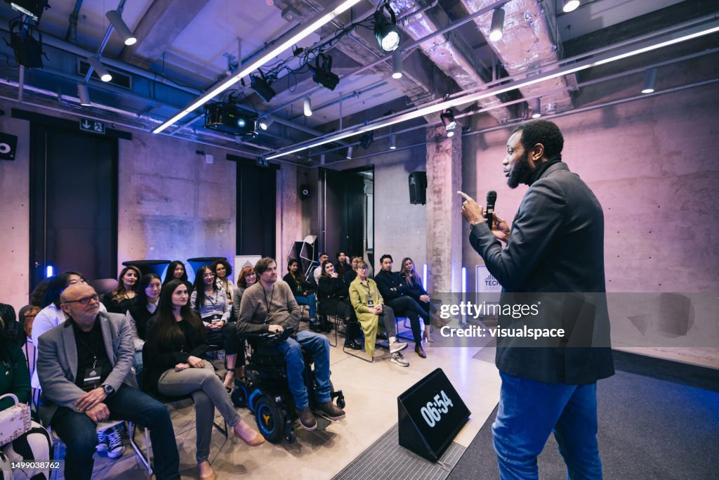 Entrepreneur giving a presentation for a diverse audience at conference