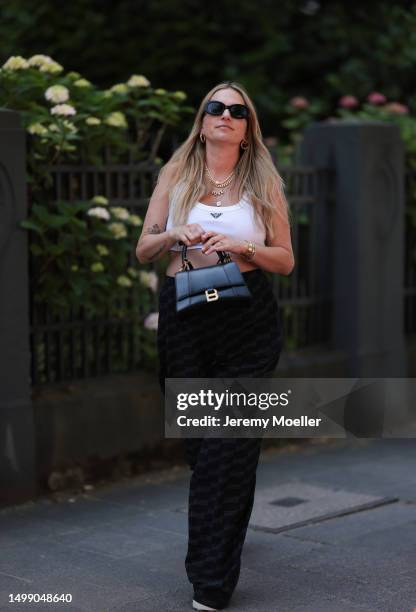 Michi Brandl wearing Prada white logo crop top, Balenciaga black parachutes logo pants, Balenciaga black leather Hourglass bag, Copenhagen Studio...