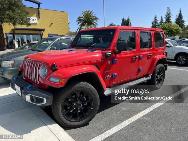 Red Jeep Wrangler 4xe Sahara electric vehicle parked in a lot at Shadelands Business Park, Walnut Creek, California, May 24, 2023.