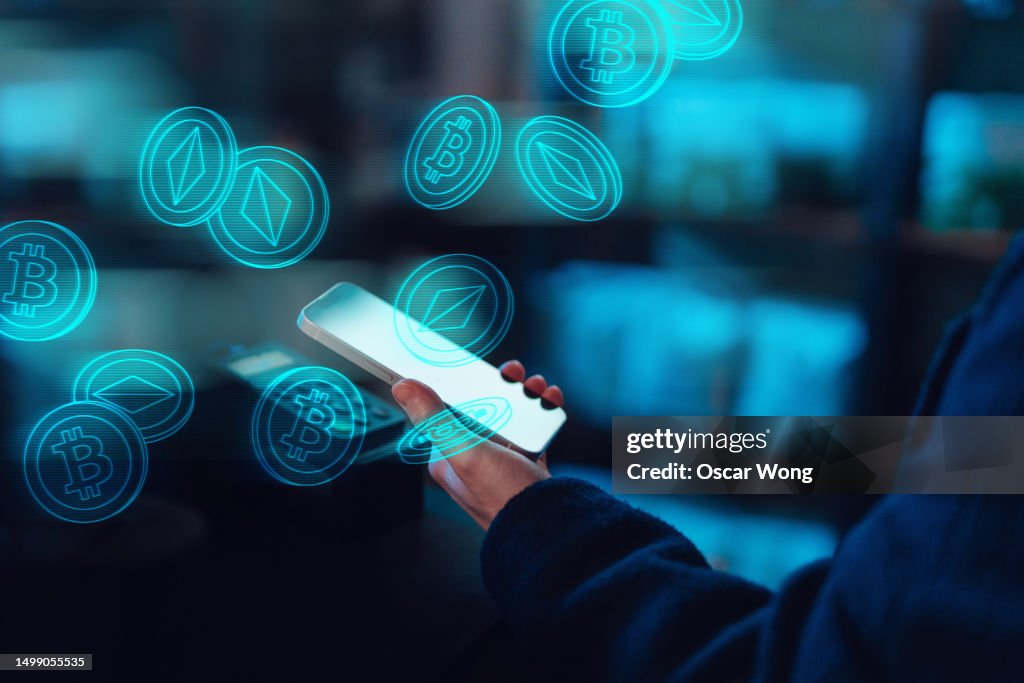 Close-up of female hand using mobile app, investing and trading digital currency on smartphone