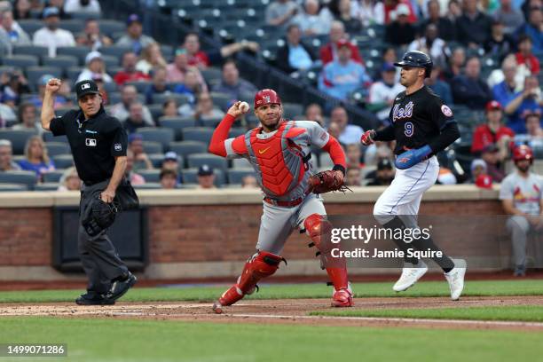 Catcher Willson Contreras of the St. Louis Cardinals throws toward first base for a double play after stepping on home plate for a bases-loaded force...