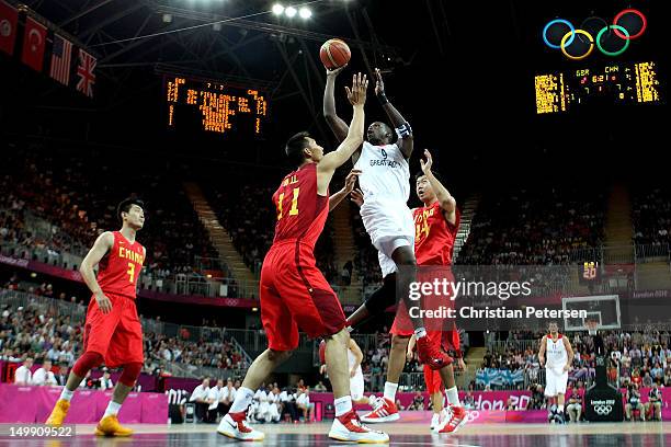 Luol Deng of Great Britain drives for a shot attempt against Yi Jianlian and Wang Zhizhi of China during the Men's Basketball Preliminary Round match...