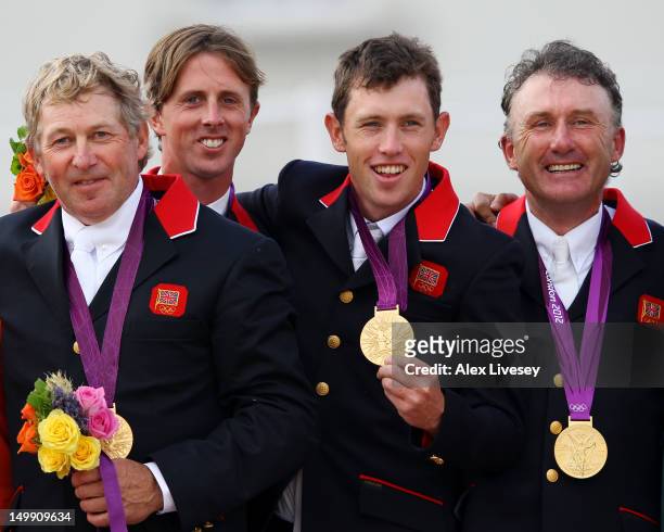 Gold medalists Nick Skelton, Ben Maher, Scott Brash and Peter Charles of Great Britain celebrate on the podium during the medal ceremony for the Team...
