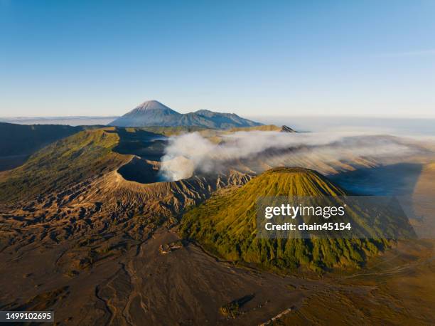 breath of bromo. aerial view from drone of bromo volcano with smoke in the morning sunrise. east java, indonesia. - vulkan rinjani stock-fotos und bilder