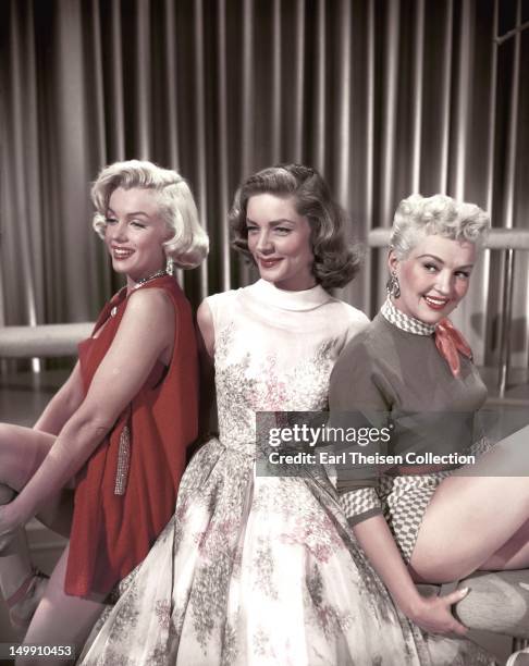 Marilyn Monroe, Lauren Bacall and Betty Grable pose for a portrait on the set of the 20th Century-Fox film 'How to Marry a Millionaire' in 1953 in...