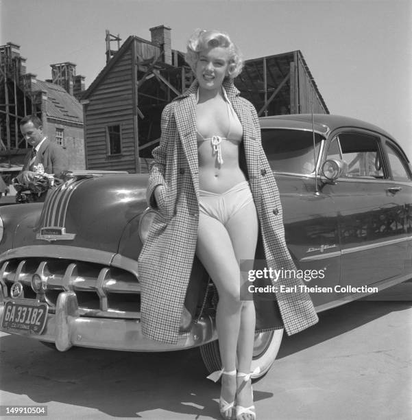 Rising star Marilyn Monroe poses for a portrait next to a 1950 Pontiac Chieftain on the backlot of 20th Century-Fox in 1951 in Los Angeles,...