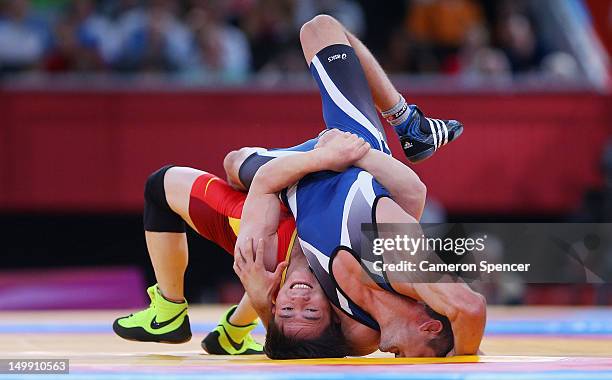 Ivo Serafimov Angelov of Bulgaria competes against Jiang Sheng of China during the Men's Greco-Roman 60 kg Wrestling Repechage on Day 10 of the...