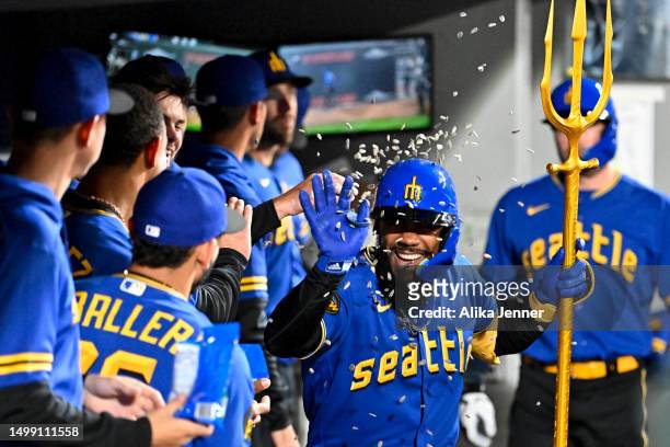 Teoscar Hernandez of the Seattle Mariners celebrates with teammates in the dugout after hitting a solo home run during the seventh inning against the...