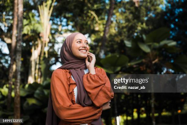 a smile is a curve that sets everything straight. - hijab fashion stockfoto's en -beelden