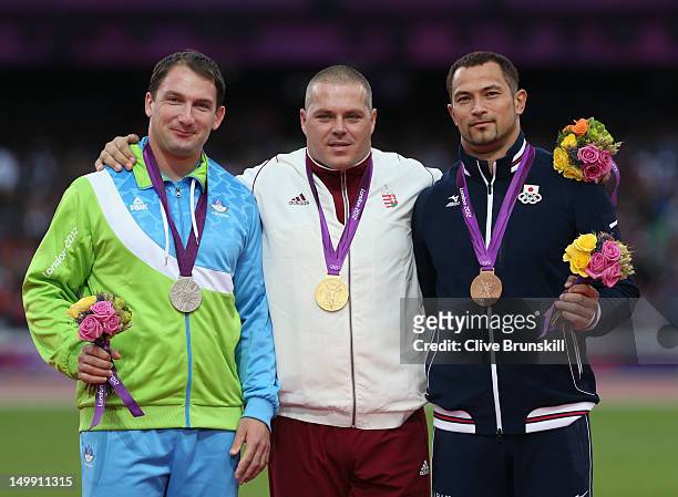 Silver medalist Primoz Kozmus of Slovenia, gold medalist Krisztian Pars of Hungary and bronze medalist Koji Murofushi of Japan pose on the podium...