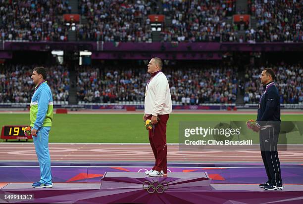 Silver medalist Primoz Kozmus of Slovenia, gold medalist Krisztian Pars of Hungary and bronze medalist Koji Murofushi of Japan pose on the podium...