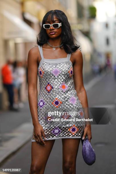 Guest wears white sunglasses from Prada, a silver large chain and pendant necklace from Tiffany, a gray glitter squared neck / tank-top tube short...