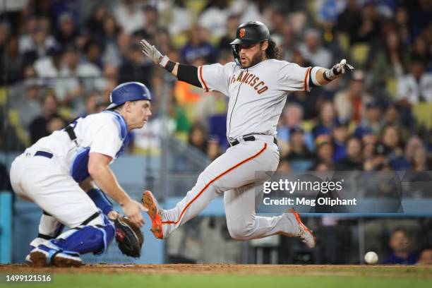 Brandon Crawford of the San Francisco Giants scores in the eighth inning against Will Smith of the Los Angeles Dodgers at Dodger Stadium on June 16,...