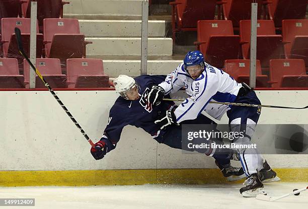 Thomas Di Pauli of the USA Blue Squad is hit by Olli Maata of Team Finland at the USA hockey junior evaluation camp at the Lake Placid Olympic Center...