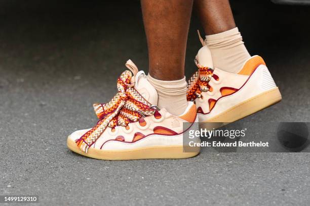 Guest wears beige socks, beige leather with orange and red details / large laces Curb sneakers from Lanvin, outside ALYX, during the Milan Fashion...