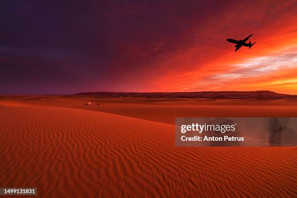 airplane over sand dunes in the desert at sunset - aeroplane sky stock pictures, royalty-free photos & images