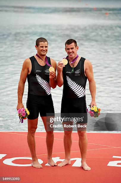 Summer Olympics: New Zealand Joseph Sullivan, stroke and Nathan Cohen, bow victorious holding up gold medals during meddal ceremony after Men's...