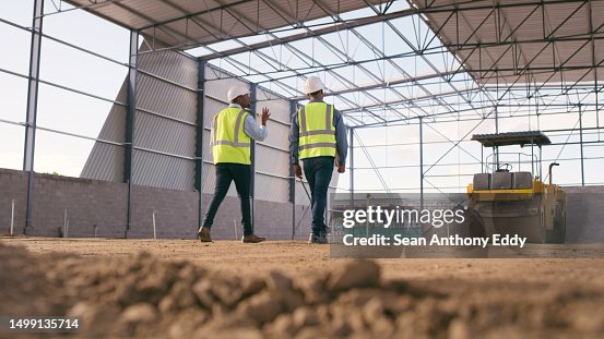 Engineering, cooperation and men on construction site planning and project management. Contractor team in warehouse, b2b in industrial service and work in building development.