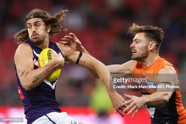 Luke Jackson of the Dockers is challenged by Stephen Coniglio of the Giants during the round 14 AFL match between Greater Western Sydney Giants and...