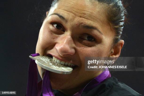 New Zealand's silver medalist Valerie Adams bites her medal on the podium of the women's shot put at the athletics event of the London 2012 Olympic...