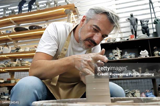 one senior man creating pottery - potter's wheel stock pictures, royalty-free photos & images