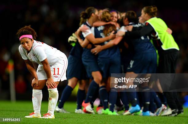 Canada's midfielder Desiree Scott reacts as the US team celebrates after the London 2012 Olympic Games women's semi final football match between the...