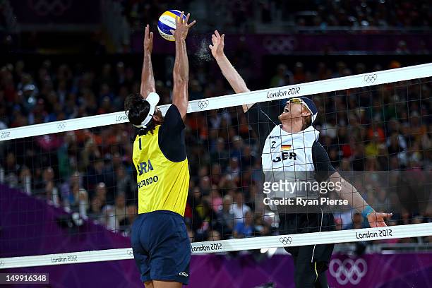 Jonas Reckermann of Germany hits a return against Ricardo Santos of Brazil during the Men's Beach Volleyball quarterfinal match between Germany and...